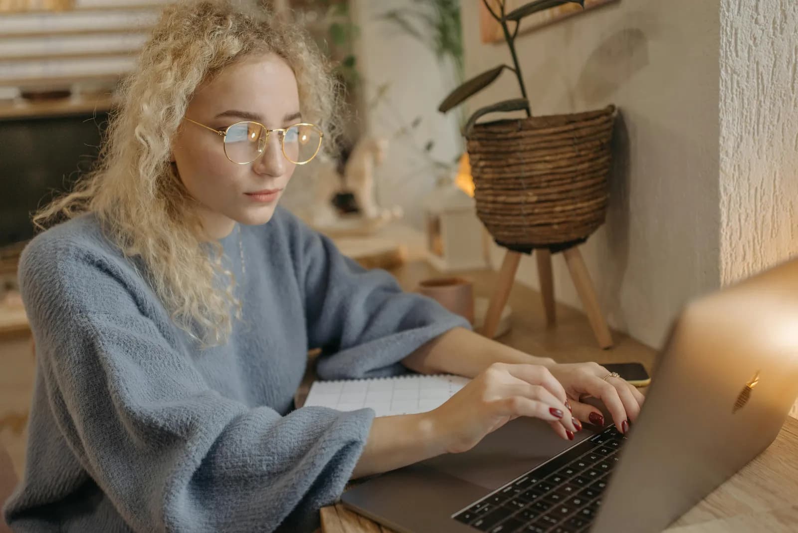 Kvinne med briller fordypet i en laptop ved et hjemmekontor