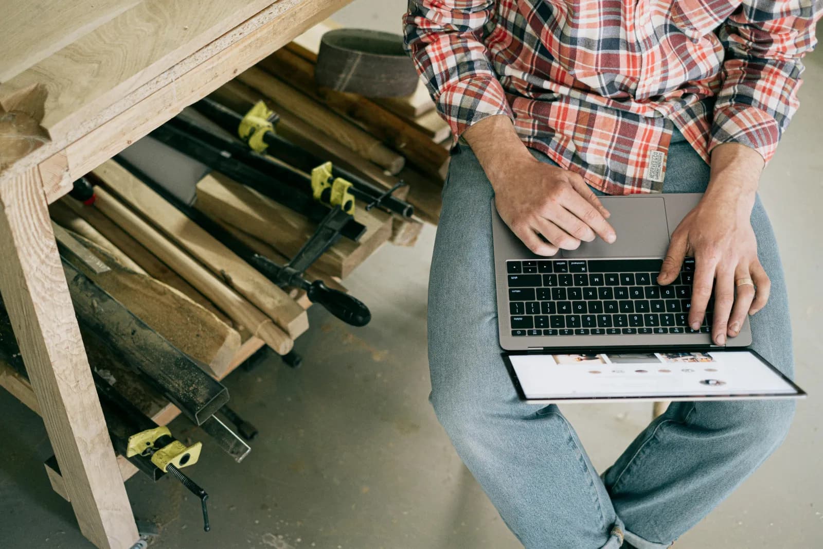 Håndverker som bruker en laptop i et verksted